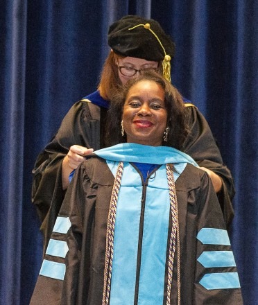 A woman is hooded after completing her doctorate at Rockhurst University