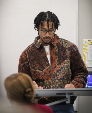 A male student stands at a drawing board