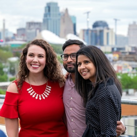 Three DO/MBA students pose in front of the KC skyline