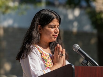 Woman standing in prayer at podium